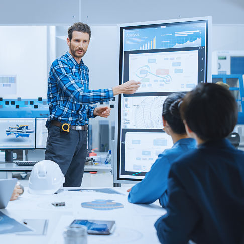 On a Meeting Chief Industrial Engineer Reports to a Group of Specialists, Managers, Uses Digital Whiteboard to Show Statistics and New Eco-Friendly Engine Concept. Sustainable Green Energy Research